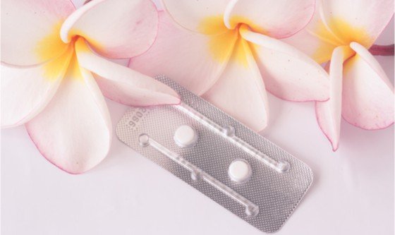 Image of e-pills and delicate frangipani flowers