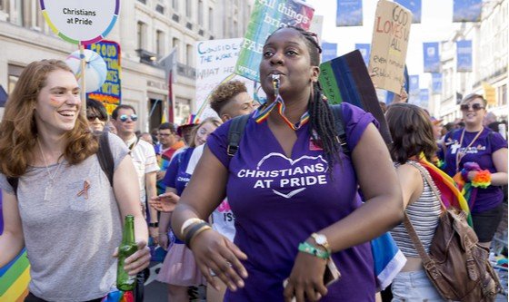 A black Christian woman wearing a Christians at Pride t-shirt