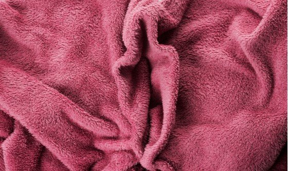 A soft purple velvet blanket folded in a way that looks like a vagina