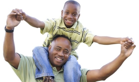 A black father and son, with the father carrying his son on his shoulders