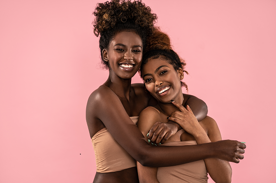 black girl hugging another from behind