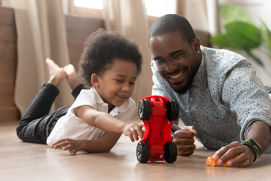 father and son praying with red toy car