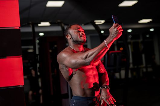 shirtless man taking a selfie 