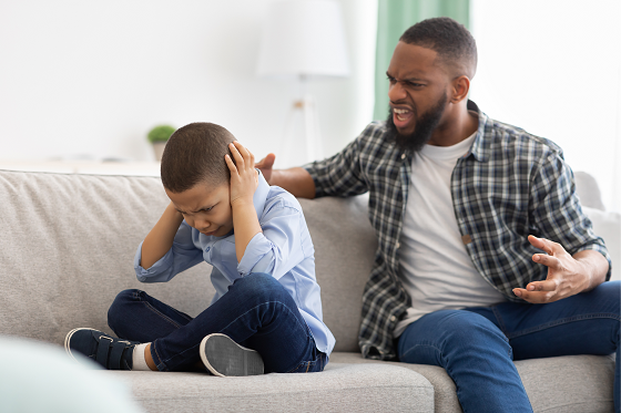 Boy being yelled at by man covers ears with both hands