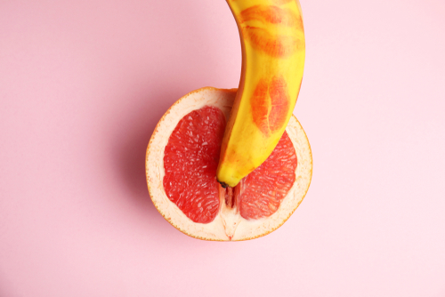 A ripe banana resting on half an orange