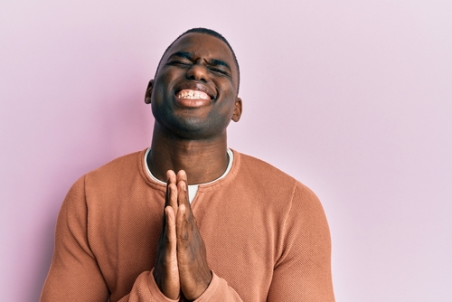 Young african american man wearing casual clothes begging and praying with hands together with hope expression on face very emotional and worried