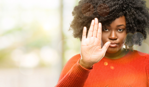 african woman annoyed with bad attitude making stop sign with hand, saying no