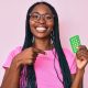 African american woman with braids holding birth control pills pointing finger to one