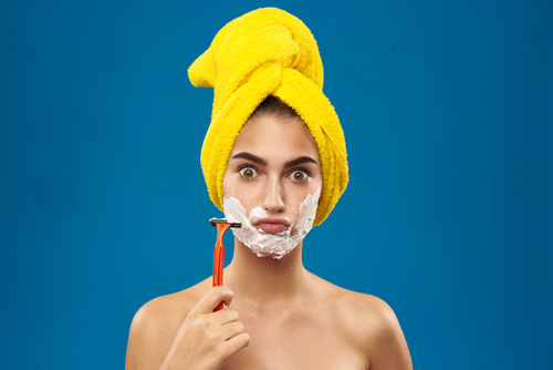 young woman shaves her face